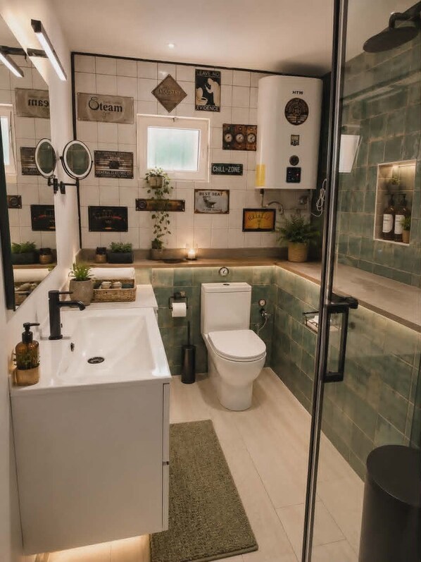 A modern bathroom with a white sink, toilet, and shower area. There are various wall decorations and a small window. - Loft with Pool near Valencia and the Ricardo Tormo Circuit (VC)