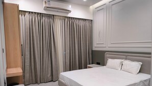 Un dormitorio moderno con una cama grande, un armario y aire acondicionado integrado.