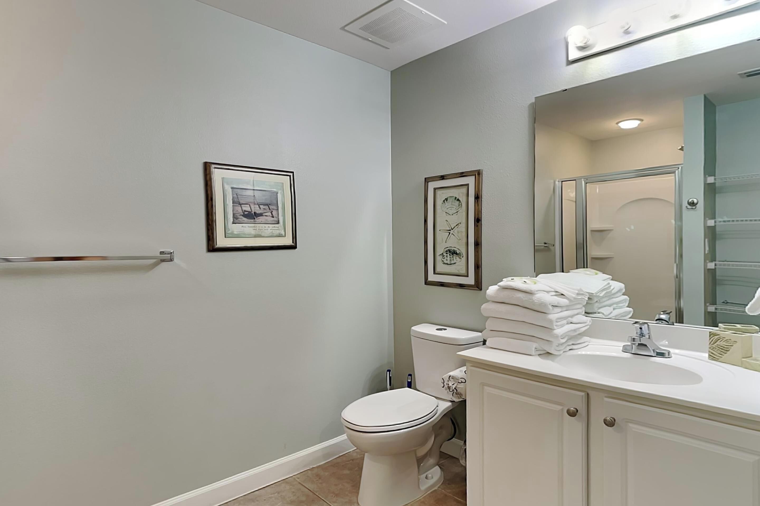 Ein Badezimmer mit Toilette, Waschbecken und gerahmten Bildern an der Wand.