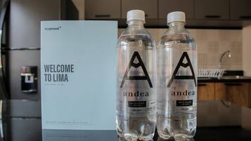 Two bottles of water with the label 'andea' and a welcome sign for 'Lima' in the background.