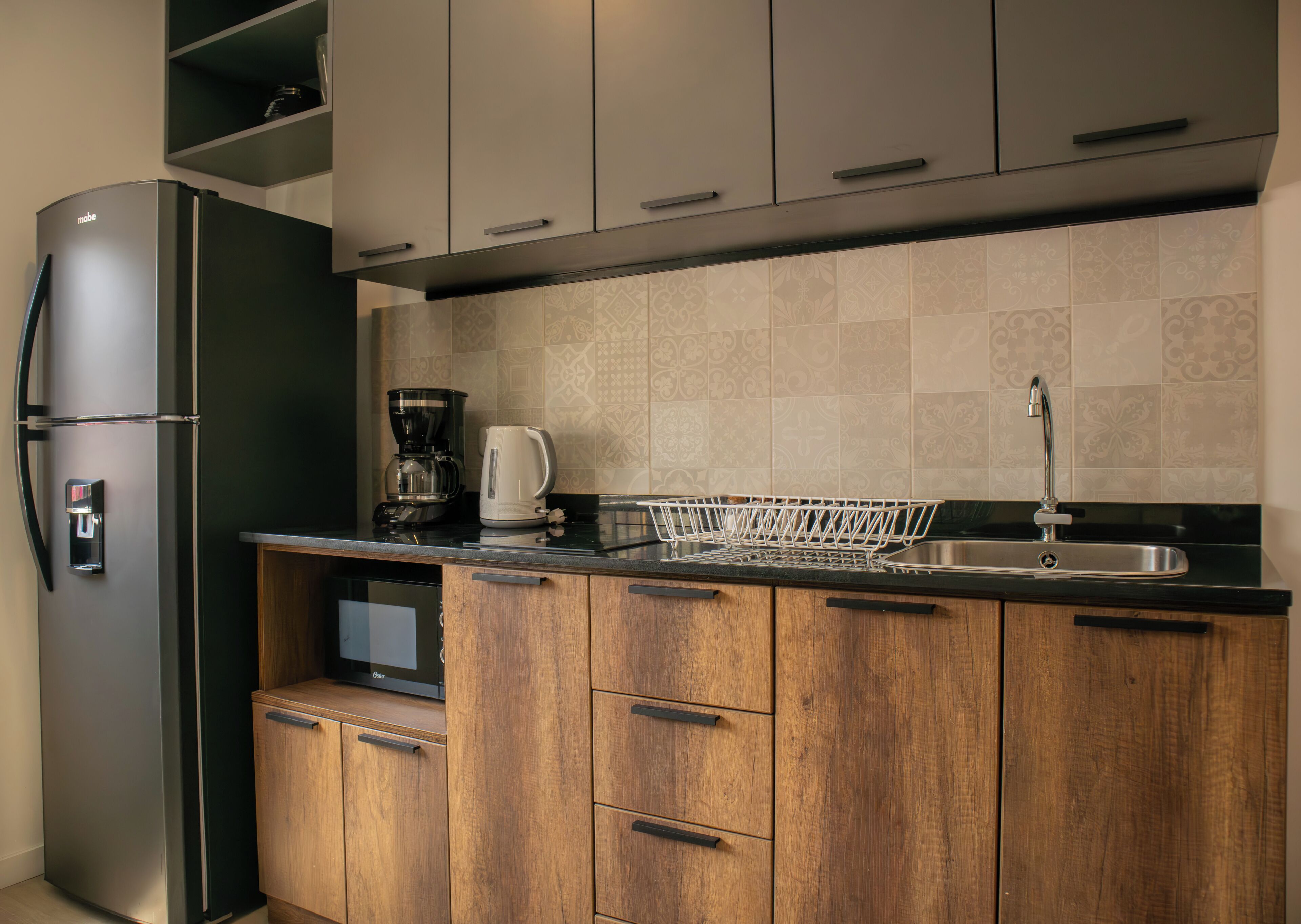 Eine moderne Küche mit einem Einbaukühlschrank, einer Kaffeemaschine und einem Spülbecken.