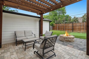 A covered patio area with a fire pit and outdoor furniture. - 0.8 Mi to AT&T | Stadium View | Walk to Games (Arlington)