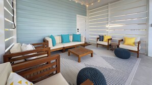 A cozy, well-lit room with a blue wall, wooden furniture, and a patterned rug. - Cape San Blas Gulf Views, Private Pool, Steps to Beach (Port St. Joe)