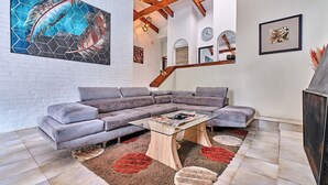 A modern living room with a sectional sofa, a glass coffee table, and a decorative rug.