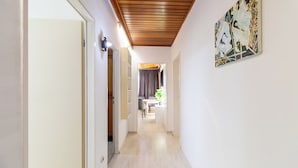 A hallway with a wooden ceiling, a dining area in the background, and a painting on the wall. - Bright, central 4-room apartment in Braunschweig (Braunschweig)