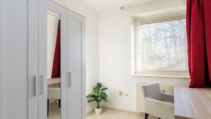 A room with a window, a radiator, a plant, and a chair. - Bright, central 4-room apartment in Braunschweig (Braunschweig)