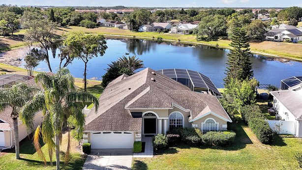 A residential property with a large pond, surrounded by greenery and other houses. - ⛱  Lake View - 4 Bed - Sunridge Wood - South Facing Pool Home ✈ (Davenport)