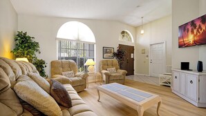 A living room with a sofa, armchairs, a coffee table, and a TV. There is a large window, a door, and a plant. - ⛱  Lake View - 4 Bed - Sunridge Wood - South Facing Pool Home ✈ (Davenport)