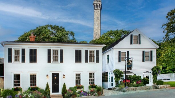 A white building with black shutters, a stone tower, and a sign reading "SILVER STAR". - Bright Queen Room with Fireplace & Skylight - Steps from Downtown Provincetown (Provincetown)