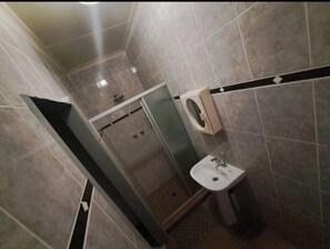 Un baño con ducha, inodoro y lavabo.