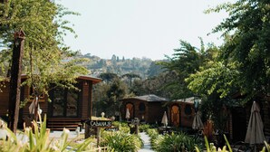 A pathway lined with plants leading to a building with outdoor seating and a sign reading "CABANA 8". - Pousada Chalés da Mantiqueira (Campos do Jordão)