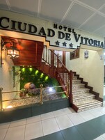 A staircase leading to a hotel entrance with a sign reading "HOTEL CIUDAD DE VITORIA".