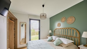 A bedroom with a bed, bedside table, lamp, and a wardrobe.