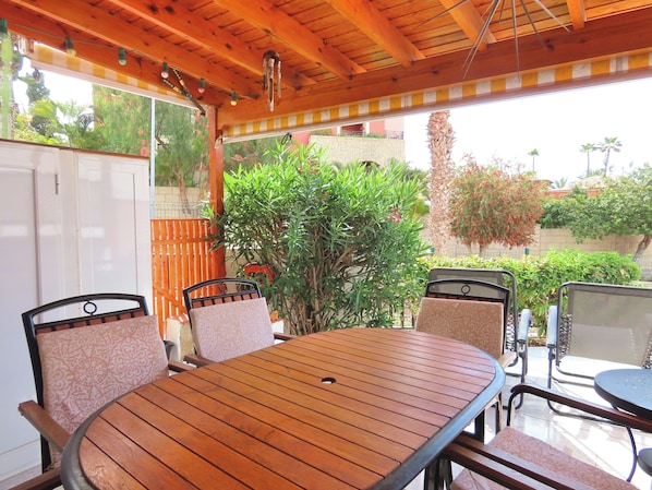Relax in this serene outdoor space with a wooden table and comfortable seating for four.