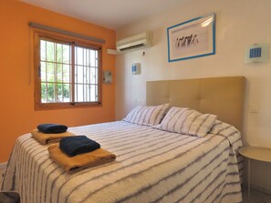 Relax in this inviting room with a large bed, air conditioning, and a convenient table.