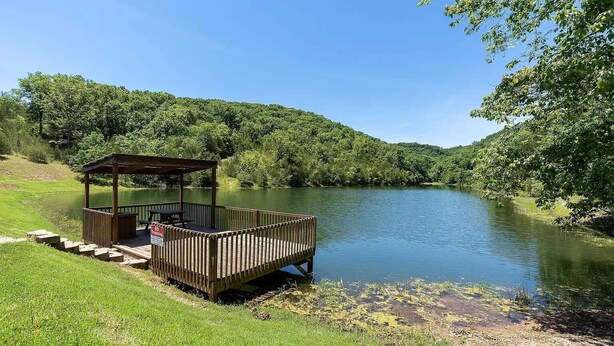 A wooden deck with a gazebo, a picnic table, and a sign indicating no swimming. - Cozy Romance Vibes! 1 mile from Silver Dollar City-2 Pools-Free Boat Parking  (Reeds Spring, Mo)