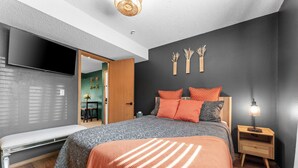 A modern bedroom with a large bed, a bedside table with a lamp, and a wall-mounted TV. - Cozy Romance Vibes! 1 mile from Silver Dollar City-2 Pools-Free Boat Parking  (Reeds Spring, Mo)