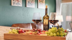 A wooden board with grapes, strawberries, and a bottle of wine, along with two wine glasses on a table. - Cozy Romance Vibes! 1 mile from Silver Dollar City-2 Pools-Free Boat Parking  (Reeds Spring, Mo)