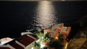 Stunning coastal views of a building with a red roof, set against a serene night sky.