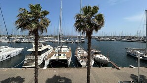 A marina with multiple boats docked, palm trees, and a clear sky. - Charming studio with sea view, Gruissan (Gruissan)