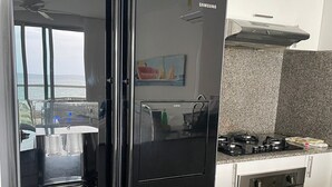 A modern kitchen with a black refrigerator, stainless steel oven, and a gas stove. - Charming 2-bedroom apartment with WiFi, AC in amazing Cartagena De Indias (Cartagena De Indias)