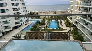 A resort with a pool area, palm trees, and a view of the beach and ocean. - Charming 2-bedroom apartment with WiFi, AC in amazing Cartagena De Indias (Cartagena De Indias)