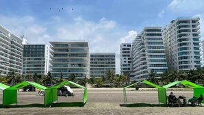 A beachfront area with modern high-rise buildings, green canopies, and a clear sky. - Charming 2-bedroom apartment with WiFi, AC in amazing Cartagena De Indias (Cartagena De Indias)