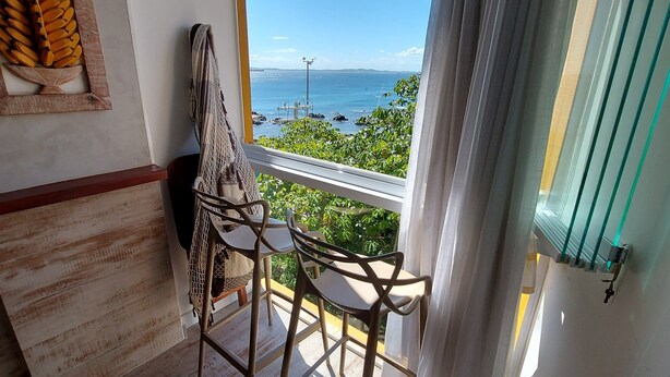 Ein Balkon mit Meerblick, einer Hängematte und einem Stuhl.