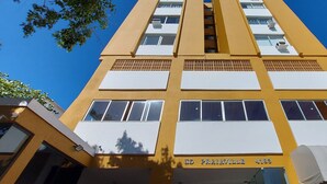 Un edificio amarillo con múltiples ventanas y un letrero que dice 'ED POKAVILLE 4183'.