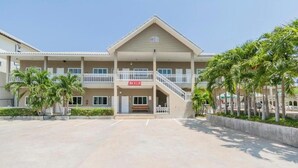 A hotel with a central entrance, multiple balconies, and palm trees. - Blue Horizon (Hua Hin)