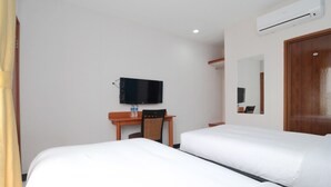 Une chambre d’hôtel avec deux lits, une télévision, un bureau, une chaise et un appareil de climatisation.