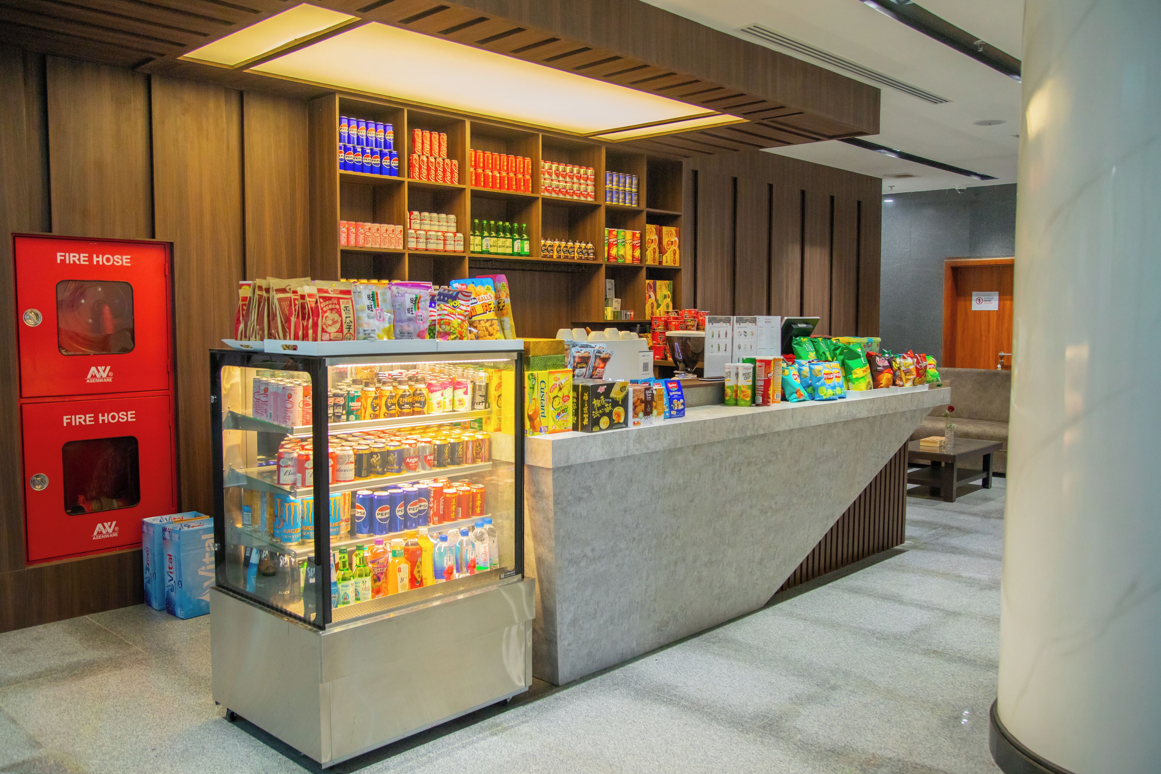 A vending area with snacks and drinks, a fire hose cabinet, and a counter with various items.