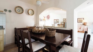 A dining area with a wooden table, chairs, and decorative plates.