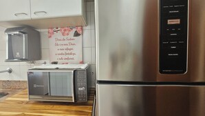 A kitchen with a toaster, microwave, and stainless steel refrigerator. - Pitangueiras Mar Azul 🌊🌴 your cozy beachfront in Guarujá. (Barra Funda Guarujá)