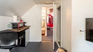 A compact living space with a kitchenette, a desk, and a red room in the background. - 2 Pvt bed Rm 1bathroom no kitchen attic (Uniondale)