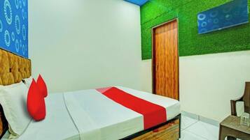 Una habitación con una cama, una puerta de madera y una pared verde.