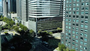 Un paisaje urbano moderno con rascacielos, un servicio de comida para llevar McDonald's y una calle bien cuidada.