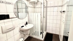 Une salle de bain avec des toilettes, un lavabo et une douche.
