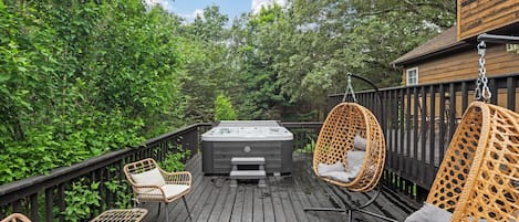 Eine Holzterrasse mit Korbstühlen und einem Whirlpool.
