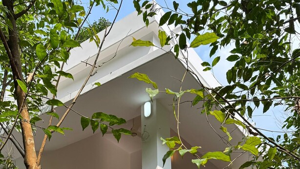A white building with a staircase leading to a balcony. - Charming 2-Bedroom Riverfront Cottage In Pleasant Pala With WiFi, AC (Pala)