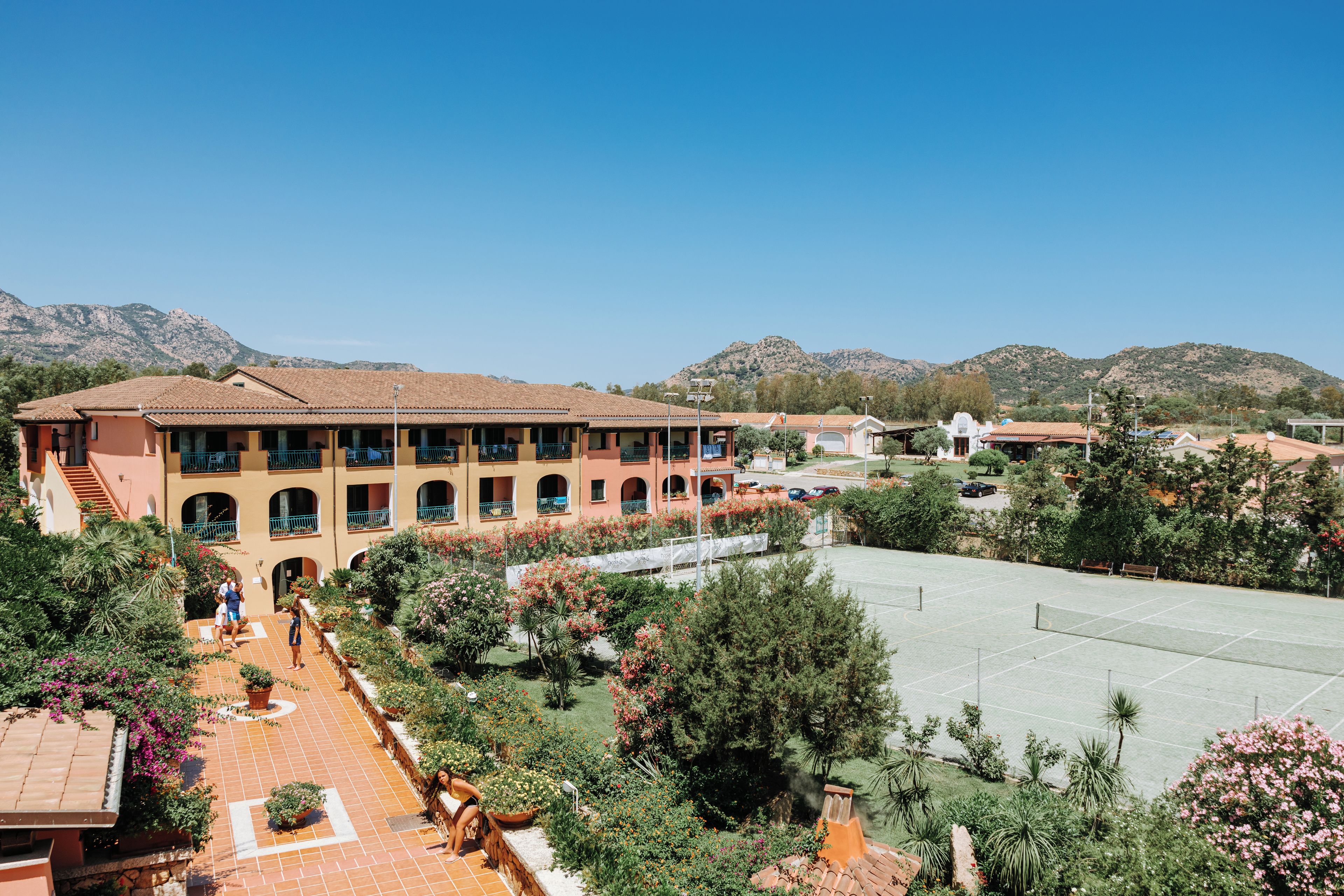 A multi-story building with a courtyard, surrounded by mountains.