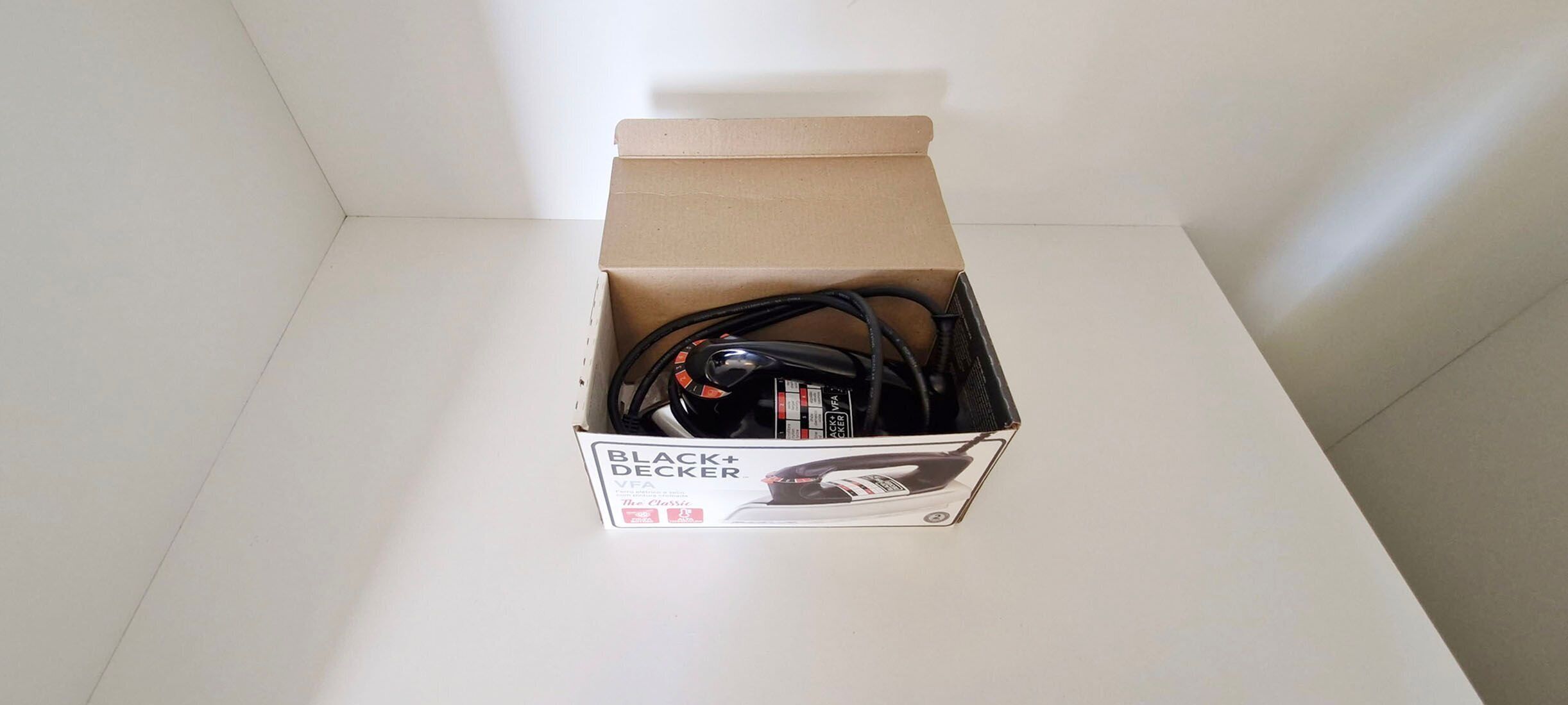 A cardboard box with a Black+Decker VFA charger on top.
