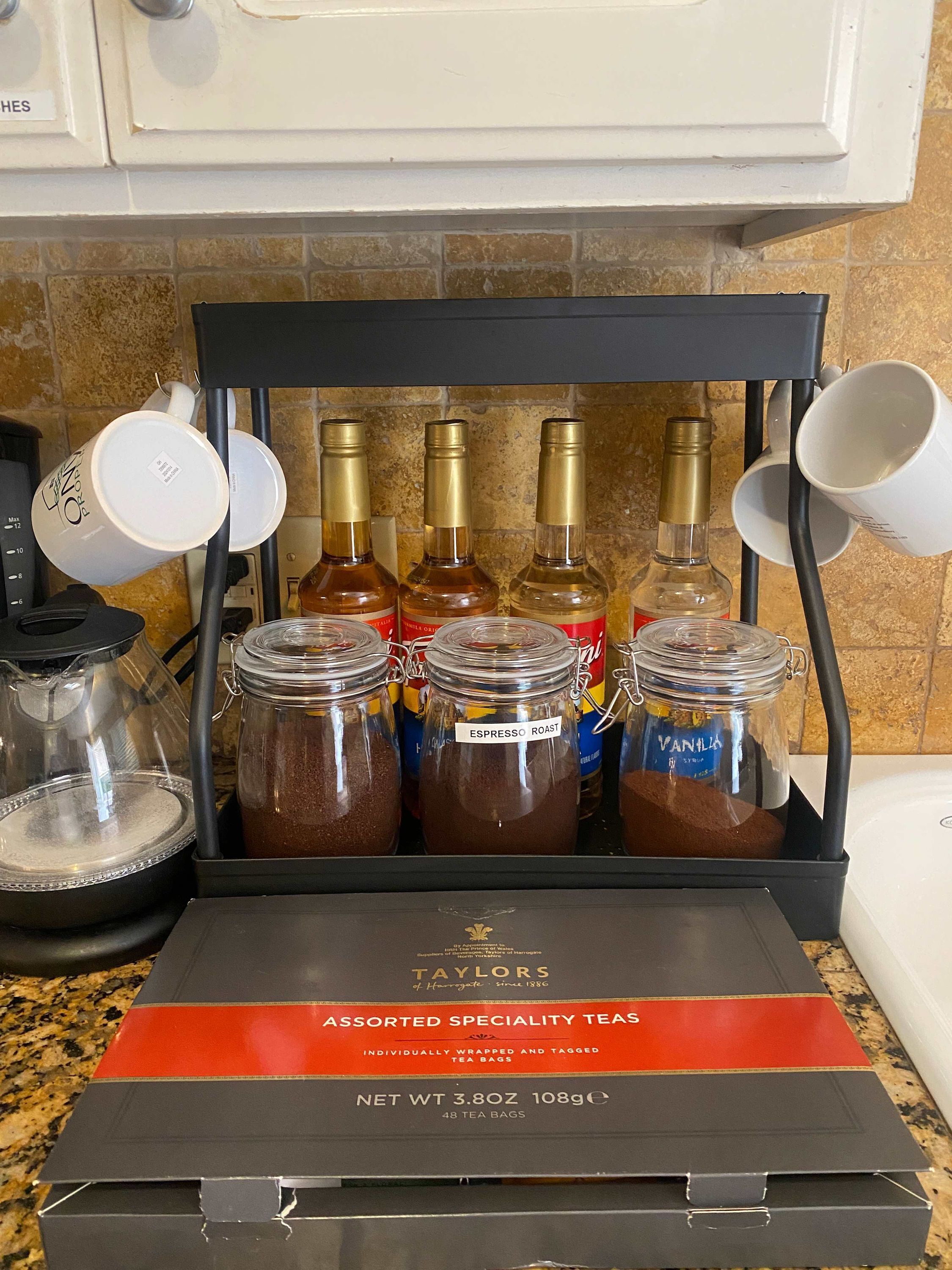 Een doos met TAYLORS Assorted Specialty Teas, met verschillende theezakjes en flesjes.
