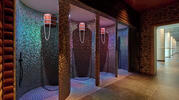 Un baño moderno con paredes de mosaicos, vigas de madera y una pared de acento de piedra.