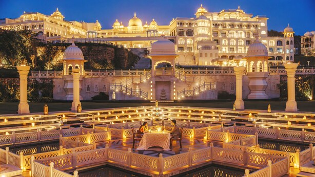 A luxurious hotel with a large central courtyard, ornate white railings, and a reflective pool. - Fairmont Udaipur Palace (Udaipur)