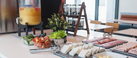 A buffet setup with various food items including fruits, vegetables, and cheeses.
