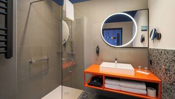 A modern bathroom with a glass-enclosed shower, a white sink, and an orange vanity.