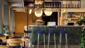 Un espace bar avec des tabourets, un comptoir et des étagères remplies de bouteilles.