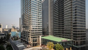 Ein modernes Hochhaus mit Glasfassade, mehreren Etagen und einer auffälligen Beschilderung oben.
