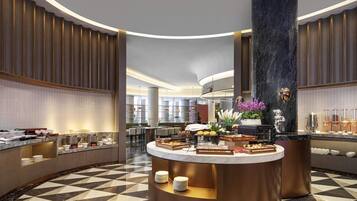 A modern hotel lobby with a central round counter, seating areas, and a large marble column.